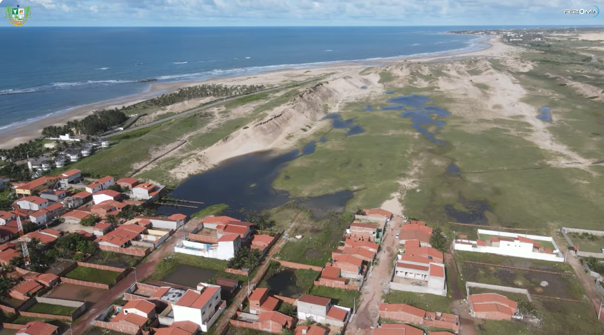 Vista aérea da vila de Emboaca entre a praia e as dunas, litoral de Trairi, Ceará