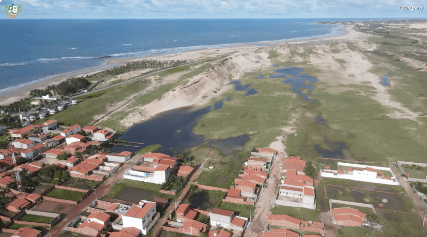 Vista aérea da vila de Emboaca entre a praia e as dunas, litoral de Trairi, Ceará