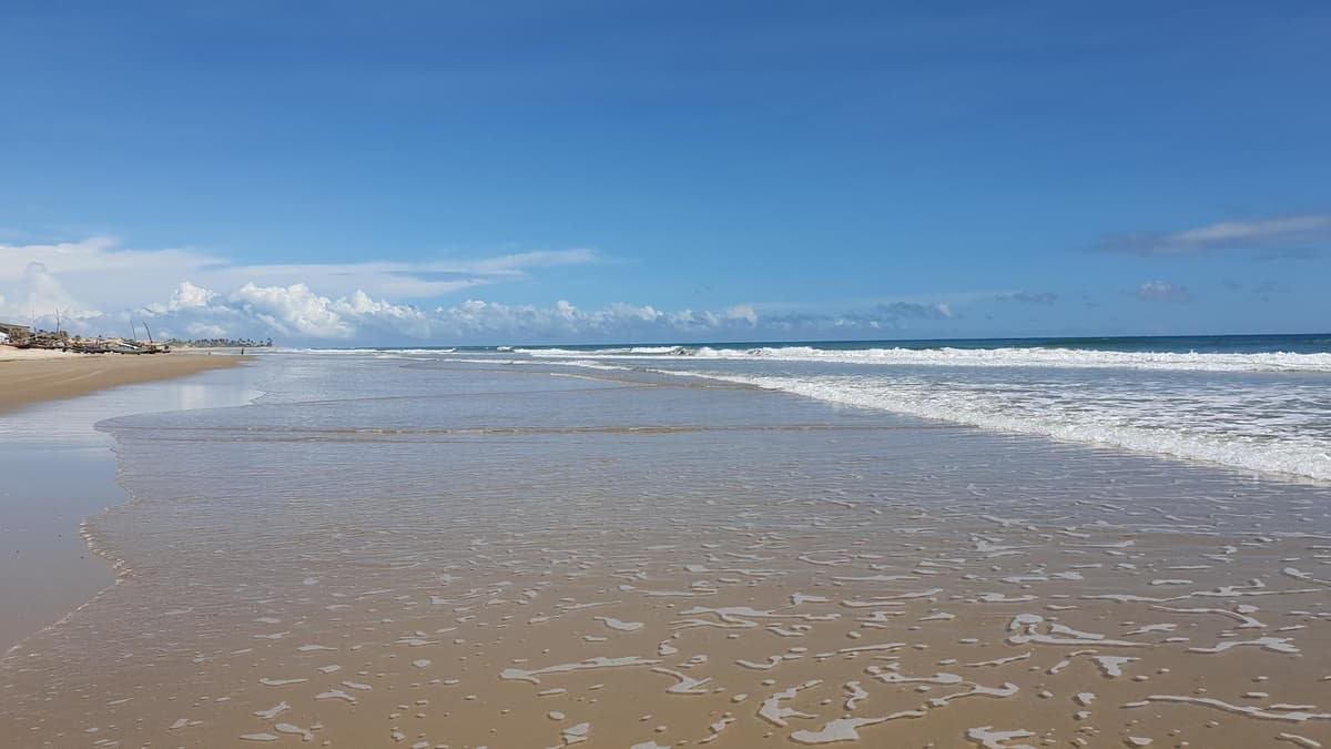 Spiaggia ampia e deserta a Cana Brava, con onde e cielo azzurro, costa di Trairi, Ceará